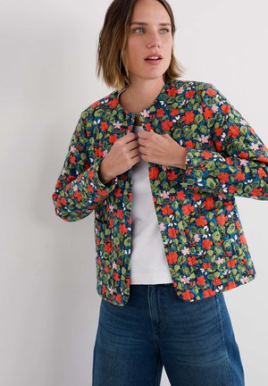 Veste matelassée en bleu marine, ornée d'un motif floral avec des accents rouges, roses et verts. Encolure ronde, manches longues et fermeture à l'avant.
