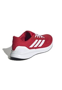 Red athletic shoe with white accents, synthetic knit upper, padded collar, and textured sole for grip. Features three white stripes on the side.