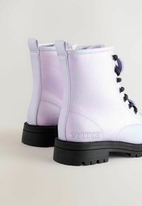 Lilla satin anklet støvler med sorte snørebånd, gummisål og let hæl. Har en tab ved kraven og "STITCH" prægning på siden.