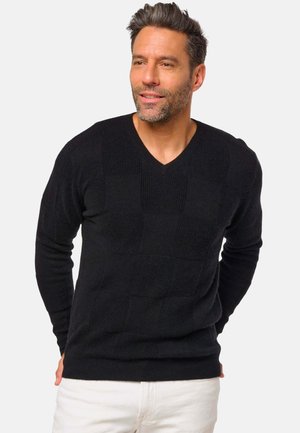Pull en maille noire avec un col en V, arborant un motif à carreaux texturé et des manches longues. Finition lisse, coupe décontractée.