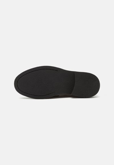 Schwarze Gummisohlen mit strukturierter Oberfläche, ovaler Form, leichtem Bogen und gestepptem Detail entlang der Kante. Gleichmäßig geformter Fersenbereich.