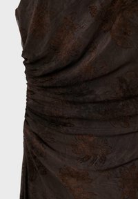 Tissu transparent marron foncé avec un subtil flocage velours floral et des détails froncés plissés au niveau de la taille et des hanches.