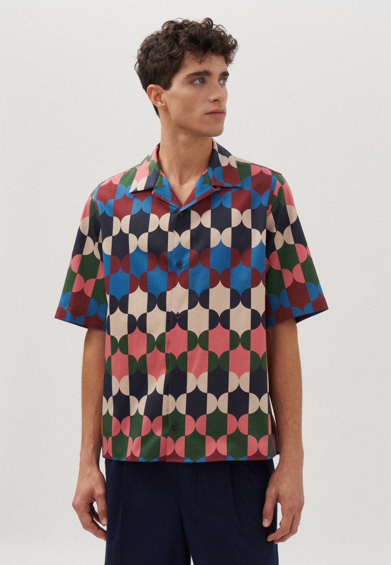 Kurzarmhemd mit geometrischem Muster in Rot, Blau, Grün und Beige. Hergestellt aus leichtem Stoff mit Kragen und Knopfverschluss.