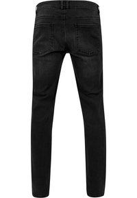 Blugi din denim negri, cu o croială slim, având un talie medie, două buzunare la spate și detalii de cusătură minime pe spate.