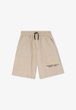 Beige casual short met een elastische tailleband, zwarte trekkoord, zijzakken en de tekst "MARC JACOBS LOCATION: N.Y.C. YEAR: 1984" gedrukt op het linkerbeen.