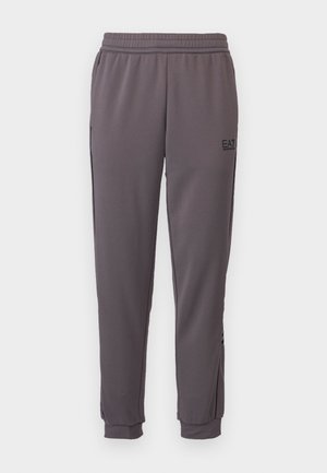 Pantaloni sportivi da uomo in tessuto grigio scuro, con vita elasticizzata, vestibilità affusolata e tasche laterali con logo sulla gamba sinistra.