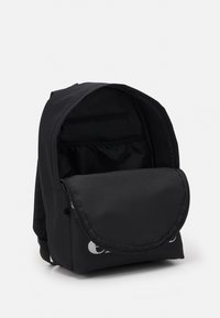 Sort rygsæk lavet af holdbart stof, med en rund flap, frontlomme med lynlås og et åbent hovedrum med et enkelt design.