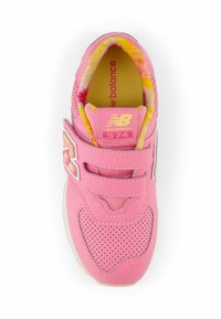 Vaaleanpunaiset New Balance 574 -lenkkarit, joissa on hengittävä verkkopinta, säädettävä tarranauha ja värikäs sisävuori. Reikäkuviointi näkyvissä.