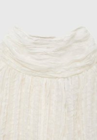 Blusa blanca con un escote acanalado texturizado y fruncido, y plisados verticales. La tela parece ligera y semi-translúcida con un patrón sutil.
