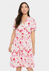 Bloemenjurk met korte mouwen in pastelkleuren en een V-hals. Heeft rode en roze bloemmotieven, een gelaagde rok en een ontspannen pasvorm.