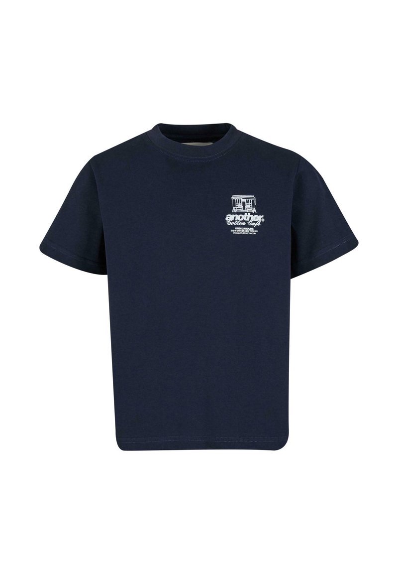 Camiseta de algodón azul marino de manga corta, con cuello redondo y estampado gráfico blanco que presenta un edificio y texto en el área superior izquierda del pecho.