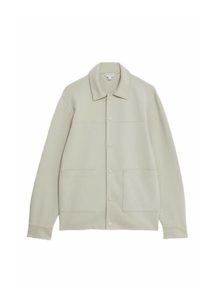 Veste boutonnée beige clair fabriquée en tissu doux, dotée d'un col, de deux poches avant et d'un design simple et épuré.