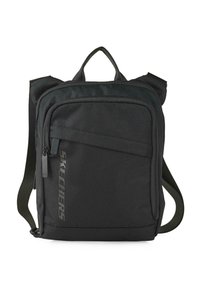 Mochila de tela negra con correas ajustables, asa superior, bolsillo frontal con cremallera y detalle de logo. Forma rectangular, textura duradera.