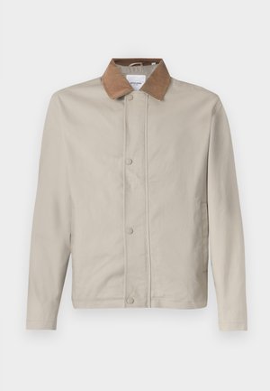 Chaqueta beige claro con cuello marrón de pana, cierre con botones a presión y bolsillos laterales. Hecha de tela suave con un diseño casual.