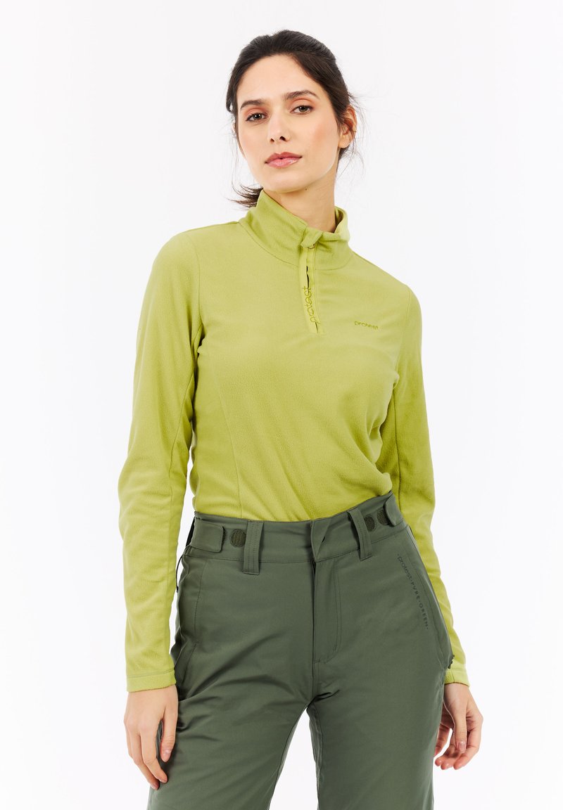 Langærmet pullover i lysegrøn fleece med høj krave og halv lynlås. Kombineret med mørkegrønne bukser med lommer.