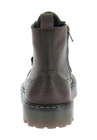 Bottes de cheville en cuir marron avec un bout arrondi, fermeture éclair sur le côté et semelle épaisse et transparente. Présente un logo en relief à l'arrière.