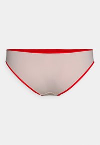 Biquíni em tom bege com acabamentos em vermelho, apresentando uma textura suave e um design de cintura baixa. Sem padrões ou hardware adicional.