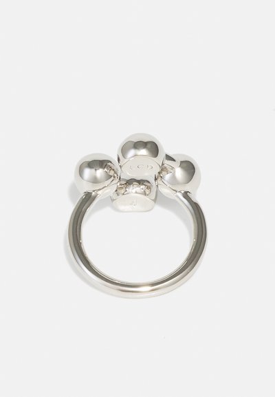 Silver metal ring featuring three spherical accents on top, smooth texture, circular shape, minimalist design, and engraved logo detail.