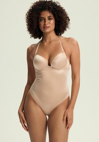 Nude jednoczęściowy kostium kąpielowy o gładkiej, połyskującej fakturze i regulowanych ramiączkach, ze słabym dekoltem i umiarkowanym odcięciem na biodrach.