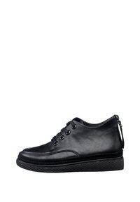 Sneaker in pelle nera con punta rotonda, sei asole e suola in gomma nera testurizzata. Presenta un tassello sul tallone per facilitare l'indossamento.