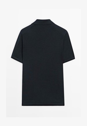 Sort polo i kortærmet med slå-krave, vist bagfra.