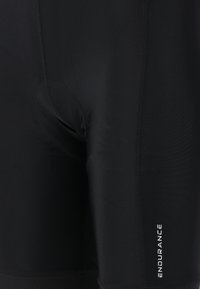 Schwarze Badeshorts aus elastischem Material mit einer körpernahen Passform, horizontalen Nähten und einem weißen "ENDURANCE"-Logo an der Seite.