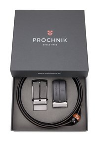 Czarny skórzany pasek z błyszczącą metalową klamrą umieszczony w ciemnoszarej pudełku. Zawiera drugą klamrę i dekoracyjny drewniany akcent.