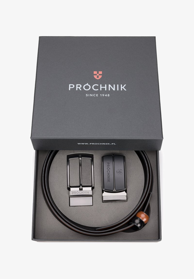 Czarny skórzany pasek z błyszczącą metalową klamrą umieszczony w ciemnoszarej pudełku. Zawiera drugą klamrę i dekoracyjny drewniany akcent.