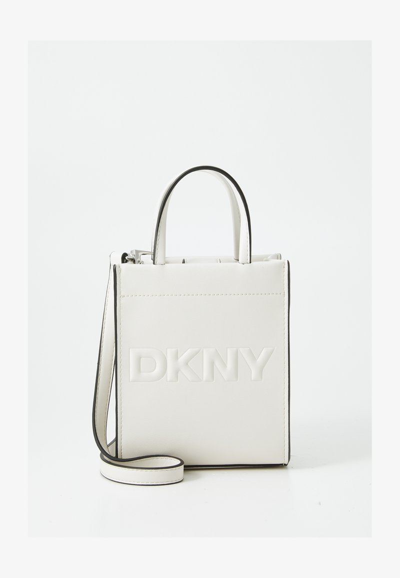 Borsa a mano in pelle bianca con bordi neri, caratterizzata da una forma strutturata e logo DKNY in rilievo sul davanti. Include una tracolla rimovibile.