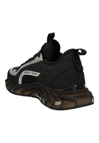 Baskets de sport noires avec une tige texturée, présentant des accents argentés et une semelle courbée distinctive. Le talon est doté d'un tirant pour faciliter l'enfilage.