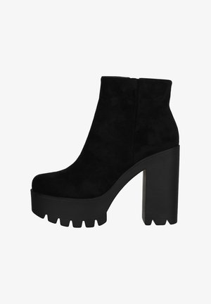 Bottines en suède noir avec une plateforme épaisse et un talon bloc haut. Présentent une finition lisse et une semelle à profil distinctif.