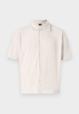 Chemise à manches courtes, couleur beige clair, avec un col et des rayures verticales. Dotée d'un boutonnage sur le devant et d'une coupe décontractée. Texture douce.