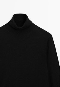 Maglione dolce di colore nero con texture lavorata a maglia, caratterizzato da un colletto ripiegato e design senza cuciture. Adatto per essere indossato a strati o da solo.