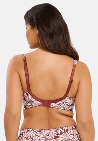 Sostenedor con estampado floral en burdeos y crema, con tirantes ajustables y cierre de gancho en la parte posterior. Textura suave.