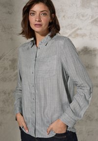 Grijs gestreepte button-up shirt van lichtgewicht stof, met een borstzak en oprolbare mouwen. Subtiele horizontale strepen en textuurdetails.