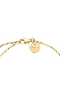 Bracciale in oro con chiusura a moschettone e un'etichetta tonda con incisione "ROSEFIELD AMST NYC", texture liscia e design minimalista.