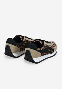 Zapatillas de leopardo con gamuza beige y acentos negros. Forma redondeada, suela de goma texturizada y diseño con cordones.