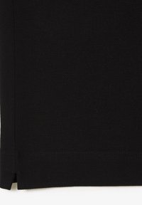 Schwarzer, strukturierter Stoff mit gewebtem Muster, ausgestattet mit sauberer Verarbeitung und seitlichen Schlitzen am Saum, die eine schlichte, gerade Form betonen.