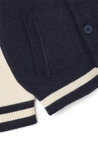 Cardigan blu navy con dettagli crema, polsini rigati e chiusura a un bottone. Presenta una texture morbida e tasche laterali.