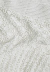 Weißer gestrickter Stoff mit einem strukturierten Muster und eingewebten Details. Oben glatt, wechselt er unten zu einem Spitzenmuster.