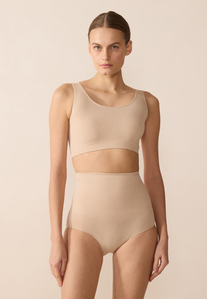 Beige two-piece set featuring a fitted crop top with wide straps and high-waisted briefs, both in a smooth, stretchy fabric.