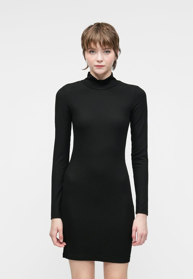 Vestido negro de manga larga acanalado con un cuello alto, ajuste ceñido y dobladillo a la altura de la rodilla. Textura suave, diseño minimalista, adecuado para superponer.