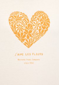 White cotton t-shirt featuring a large orange floral heart design and text that reads "J'aime les fleurs" above "Mustang Jeans Company since 1932."