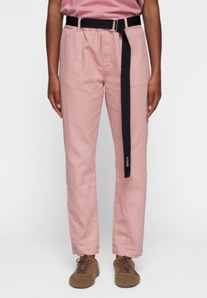 Pantaloni di cotone rosa con taglio dritto, dotati di una cintura blu scuro e tasche laterali, dal design minimalista senza motivi visibili.