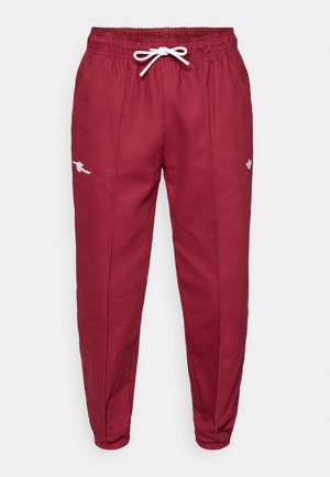 Rote Jogginghosen mit elastischem Bund und weißem Kordelzug, mit gestickten Logos am Oberschenkel und schmal zulaufendem Bein.