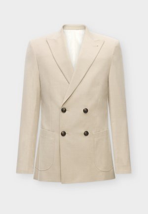 Beige dobbeltradet blazer laget av en blanding av lin. Har to frontlommer og svarte knapper. Rent, strukturert design med spisse revers.