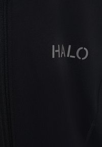 Sort stof med en lodret lynlås og ordet "HALO" trykt i gråt på højre side.