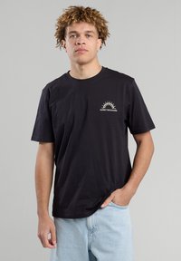 Black cotton t-shirt featuring a round neck, short sleeves, and a small white graphic with "SUNSET BOULEVARD" on the left chest.