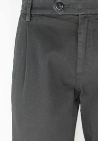 Pantaloni grigi su misura con tessuto texturizzato, pieghe frontali, chiusura con un bottone e tasche laterali inclinate.