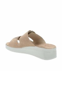 Sandalo slip-on in suede beige con design a taglio, suola in gomma bianca e soletta leggermente imbottita per il comfort. Texture complessiva liscia.